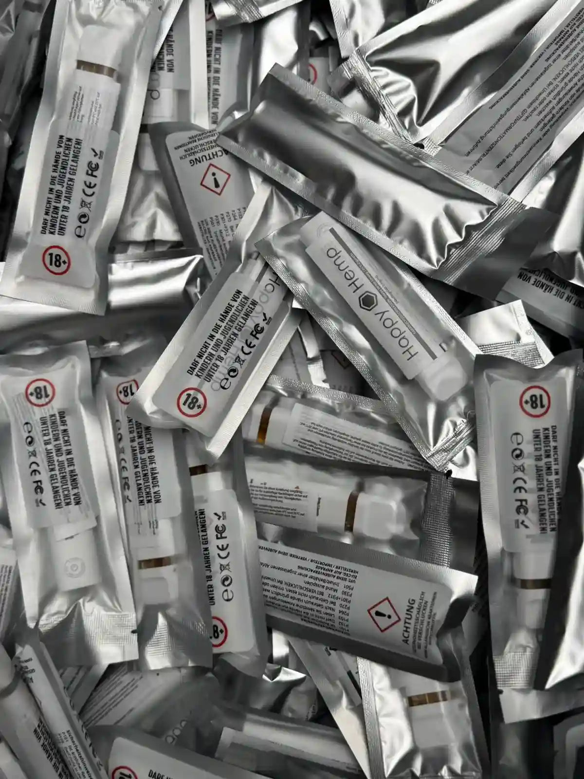 Viele H3 Ultra Vapes in silbernen Verpackungen liegen auf einem Haufen